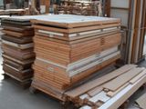 several stacks of wood sit in a large warehouse with a lot of windows