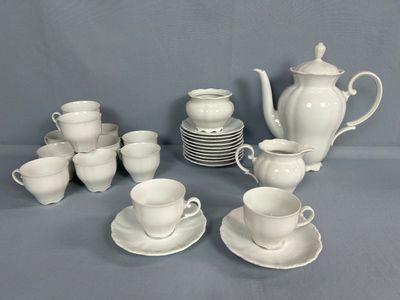 plusieurs tasses et soucoupes et une théière sur la table