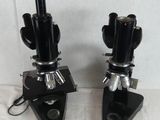 two microscopes are sitting side by side on a white surface