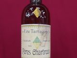 une vieille bouteille de vin posée sur une table rouge