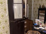 an image of a cluttered room with a chair and bookshelf