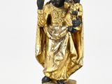 statue en or représentant un homme tenant un enfant dans ses bras, posée sur une surface blanche