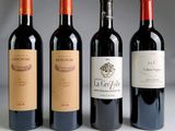 three bottles of red wine are lined up on a table