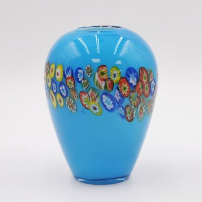 a blue vase with flowers painted on it on a white surface