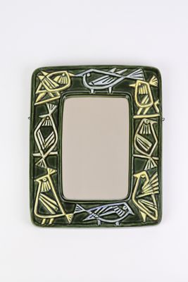 a small square mirror with a bird design on it