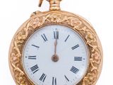 a gold pocket watch with roman numerals on it