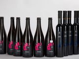six bouteilles de vin sont alignées sur une surface blanche