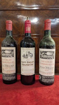 trois bouteilles de vin sont alignées sur une table rouge