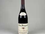 une bouteille de vin rouge posée sur une table blanche