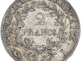 a silver coin with a wreath on the front of it