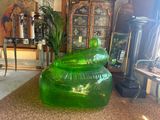 a green plastic chair sitting in a living room