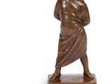 statue en bronze représentant une femme tenant un bébé dans ses bras, posée sur un socle en bois