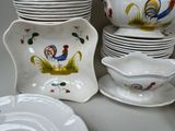 many plates and bowls with roosters painted on them