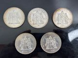 six different british coins are on display in a glass case
