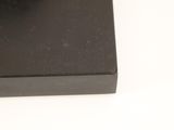 a black object on a white surface with a white background