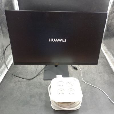 une photo représentant un écran d'ordinateur et un chargeur posés sur une table