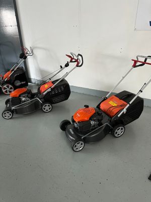 several lawn mowers are lined up in a row in a room