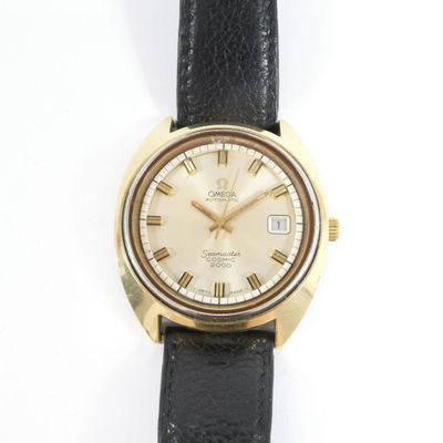 an image of a gold watch with roman numerals on a black strap
