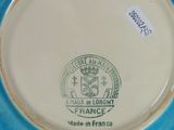 a blue and white plate with a picture of a coat of arms on it