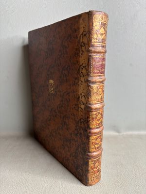 un vieux livre posé sur une table à côté d'un mur