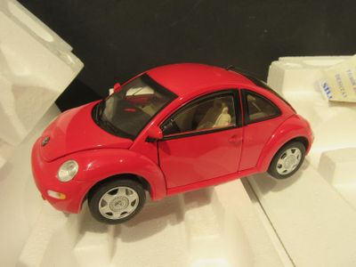 une petite voiture rouge posée sur une surface blanche