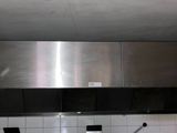une hotte en acier inoxydable au-dessus d'une cuisinière dans une cuisine