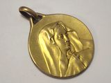 an image of a gold medal with a woman ' s face on it