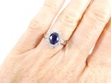 an image of a woman ' s hand with a diamond and sapphire ring