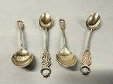 four silver spoons and two silver spoons on a white surface