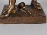 bronze statue of a man with a baseball bat and ball on a wooden base