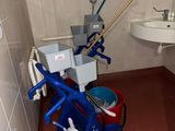 une petite salle de bains avec une serpillière et des seaux à l'intérieur