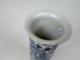 a blue and white vase sitting on a white surface