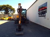 a backhoe of a construction vehicle parked in front of a building