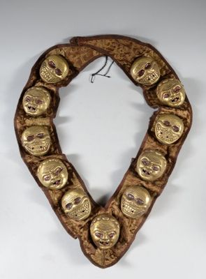 un gros plan sur un collier en or orné de têtes de mort