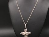 un collier en argent orné d'un ange, porté par un mannequin