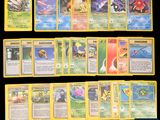 Plusieurs cartes Pokémon sont alignées sur une surface noire