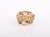 a close up of a gold ring with blue stones
