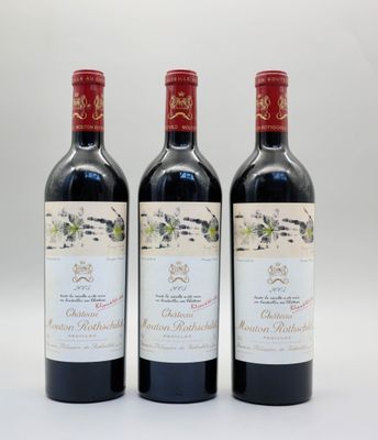 trois bouteilles de vin rouge posées l'une à côté de l'autre sur une surface blanche
