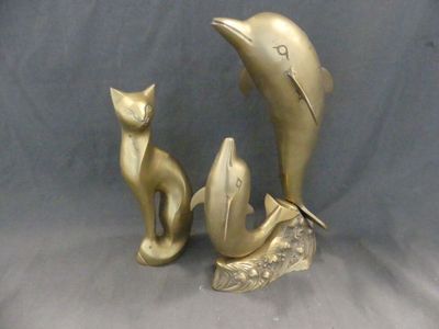 deux figurines en or représentant un chat et un dauphin
