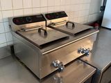 stainless steel counter top with two deep fryers on top of it