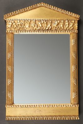 un miroir à cadre doré orné d'un motif décoratif, accroché au mur