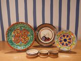 four plates and bowls on a table with a striped wall in the background