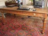 une table en bois sur laquelle est posé un ordinateur portable