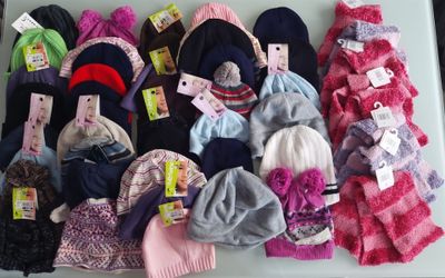 beaucoup de bonnets et d'écharpes posés sur une table
