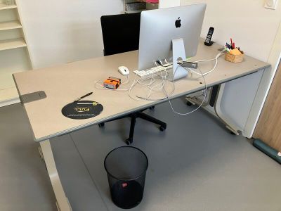un bureau sur lequel se trouvent deux ordinateurs et une poubelle