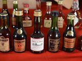 many bottles of alcohol lined up on a red table