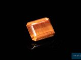 gros plan d'un diamant orange sur une surface noire