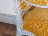 a yellow and white chair that is on a wooden floor