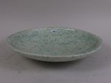 a green bowl sitting on a table with a sticker on it