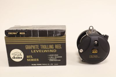 an image of a black and gold reel next to a box